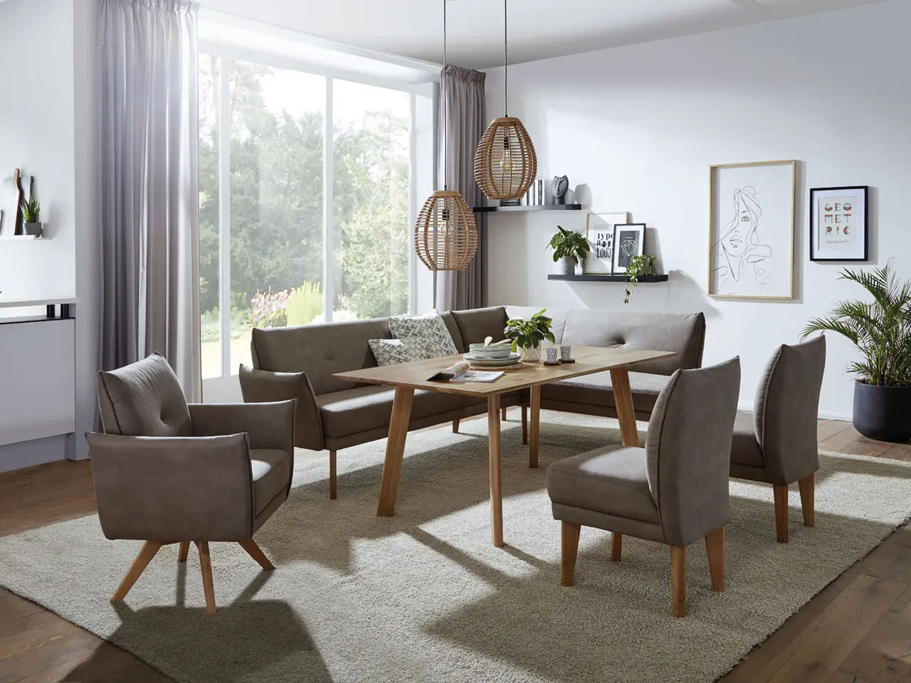 Esszimmer mit Holztisch, Eckbank, zwei Stühlen, Teppich und großen Fenstern
